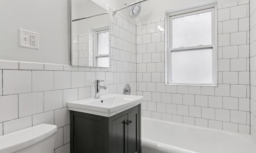 a bathroom with a tub sink and mirror