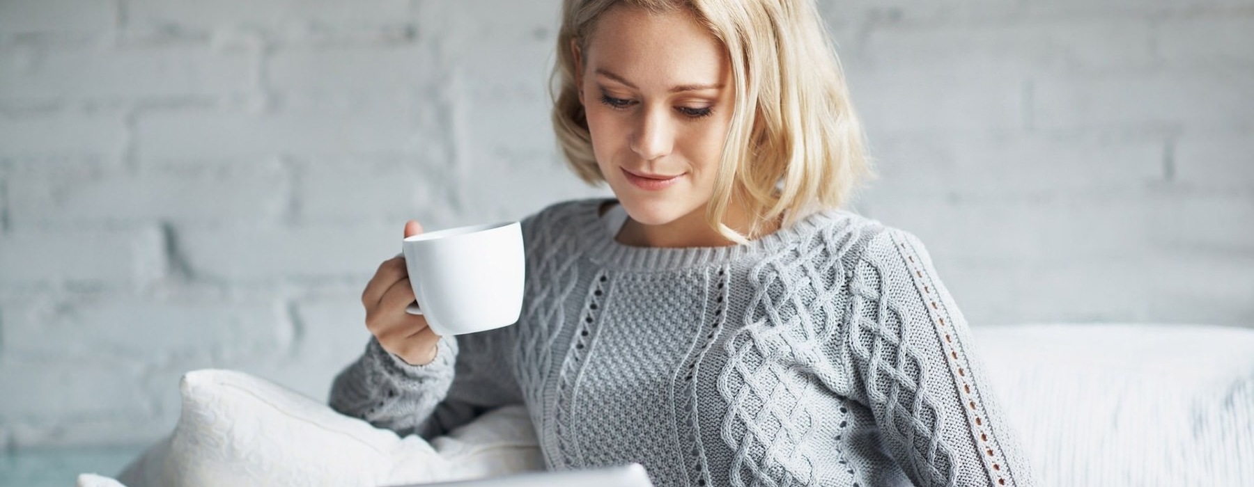 a woman holding a cup and a tablet