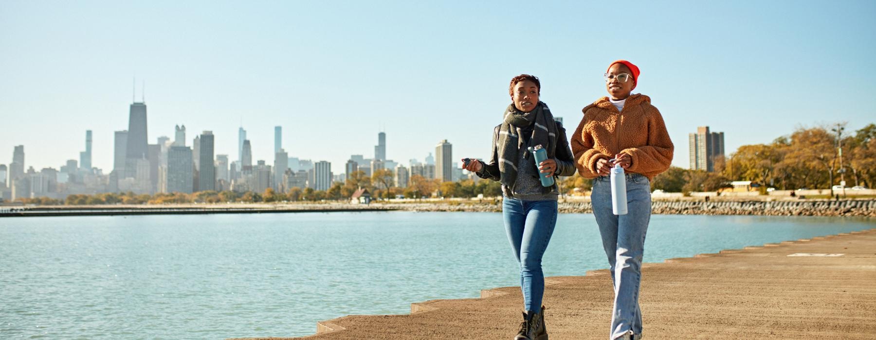 a man and woman posing for a picture by a body of water