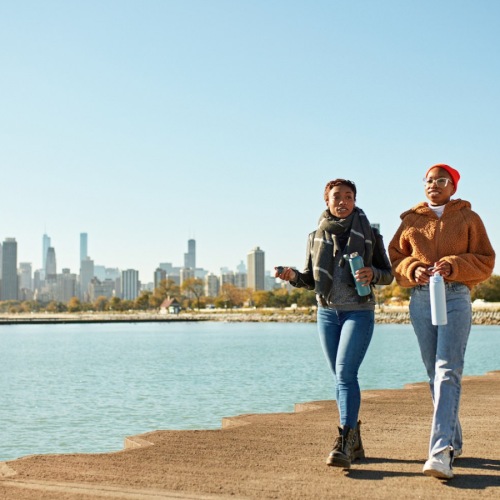 Close to the center of everything two people walking near the beach near a city