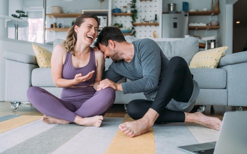 a man and woman sitting on the floor and smiling